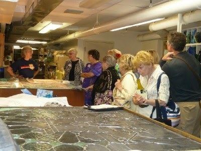 Members talking to stained glass window technician.